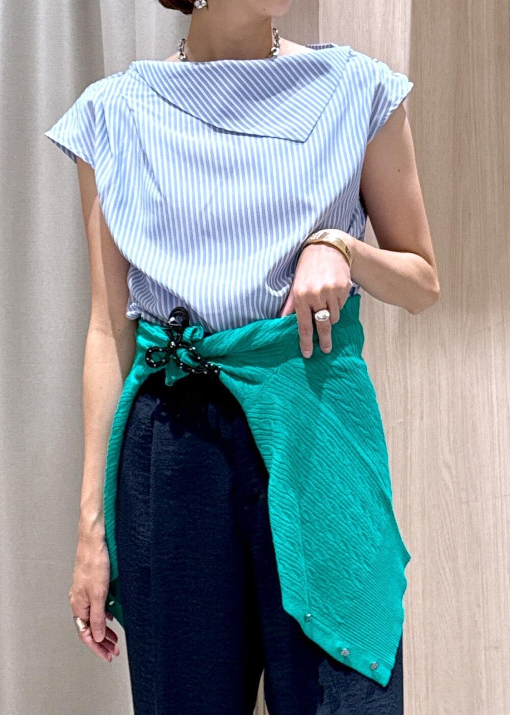 シルバー系のパンプス、ブラック系のハンドバッグ、ブルー系のスラックスを着用したレディースの夏コーディネートの9枚目の写真