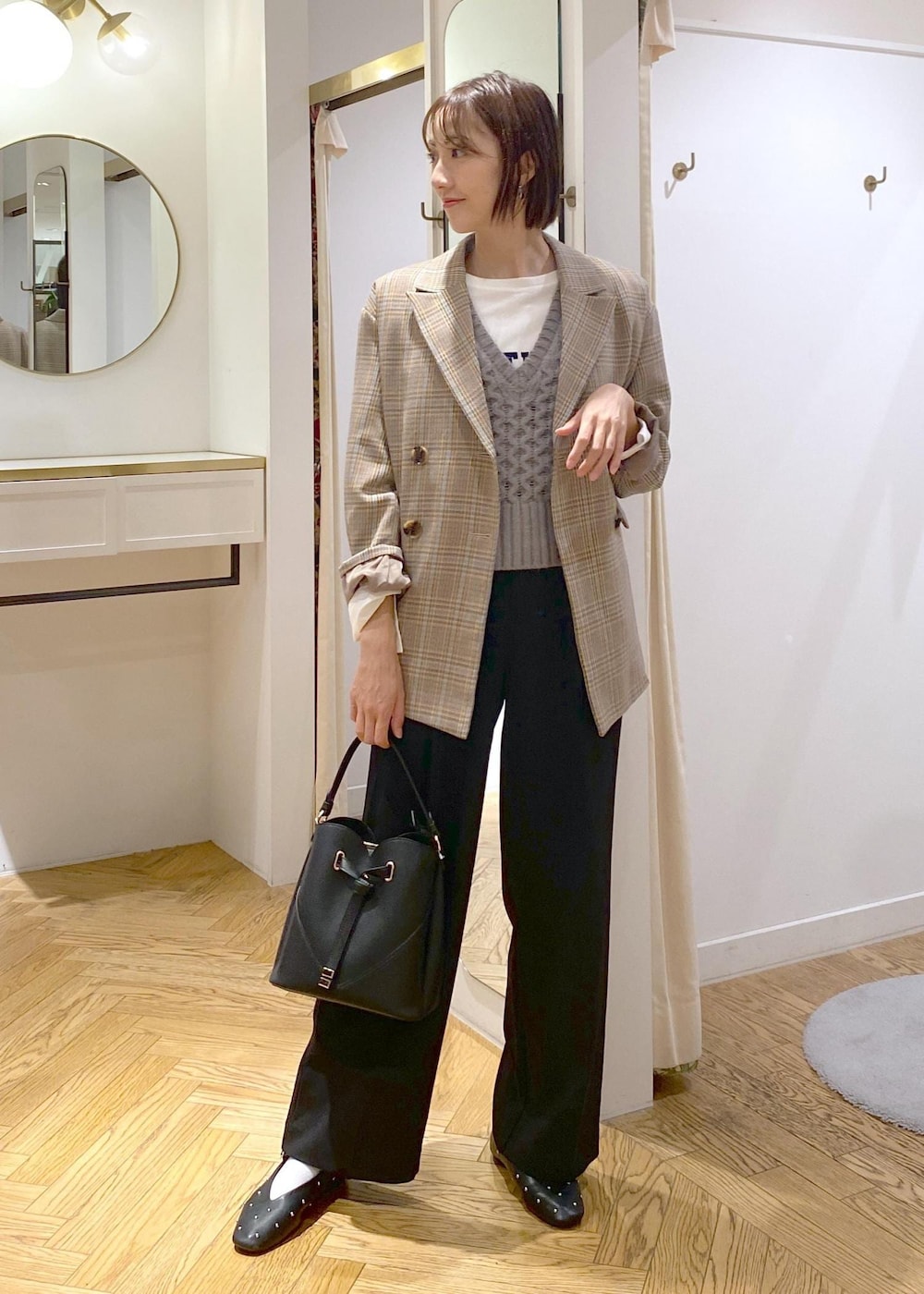 ブラック系のショルダーバッグ、ブラック系のバレエシューズ、ホワイト系のTシャツ/カットソーを着用したレディースの秋コーディネートの3枚目の写真