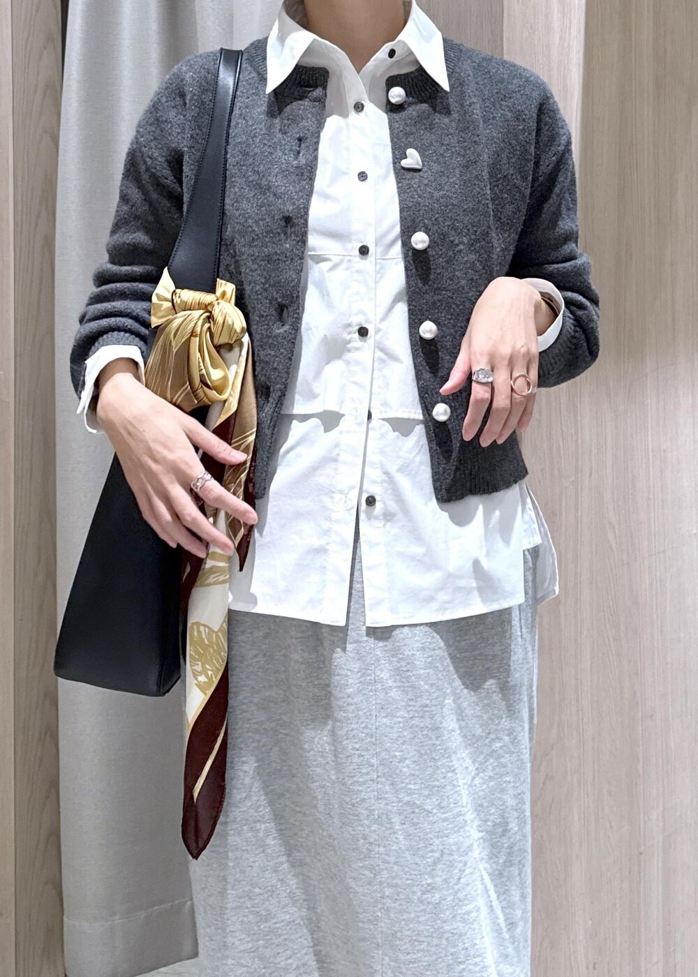 ブラック系のトートバッグ、グレー系のスカート、ホワイト系のシャツ/ブラウスを着用したレディースの秋コーディネートの8枚目の写真