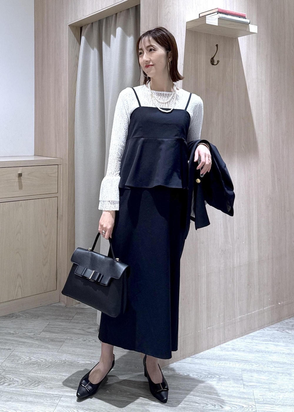 ブラック系のパンプス、ブルー系のテーラードジャケット、ブルー系のワンピースを着用したレディースの冬コーディネートの7枚目の写真