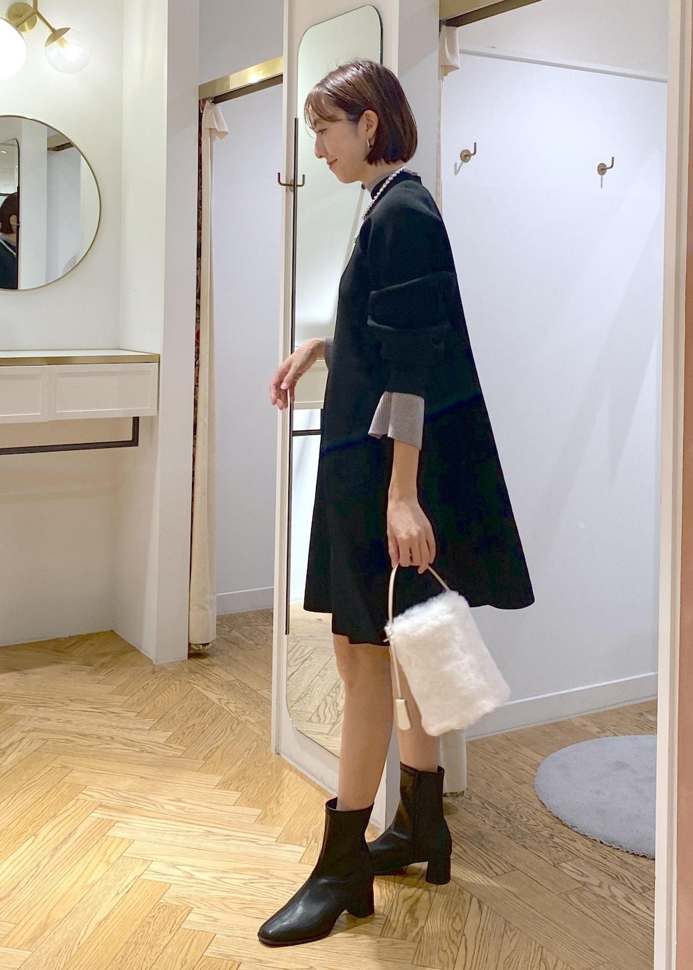 ブラック系のブーツ、ブラック系のワンピース、グレー系のニット/セーターを着用したレディースの秋コーディネートの2枚目の写真