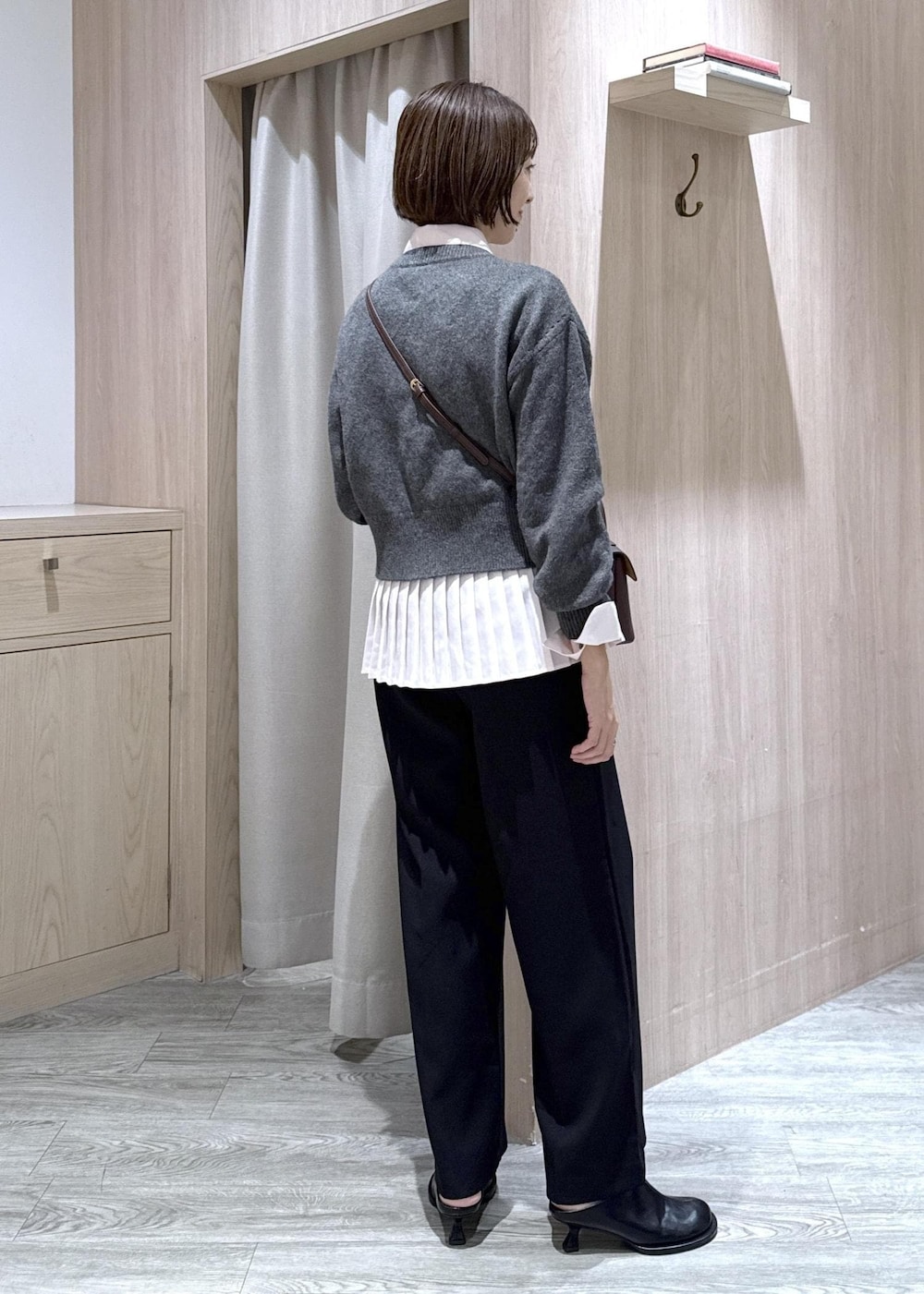 ブラウン系のショルダーバッグ、ブラック系のスラックス、グレー系のカーディガン/ボレロを着用したレディースの秋コーディネートの4枚目の写真