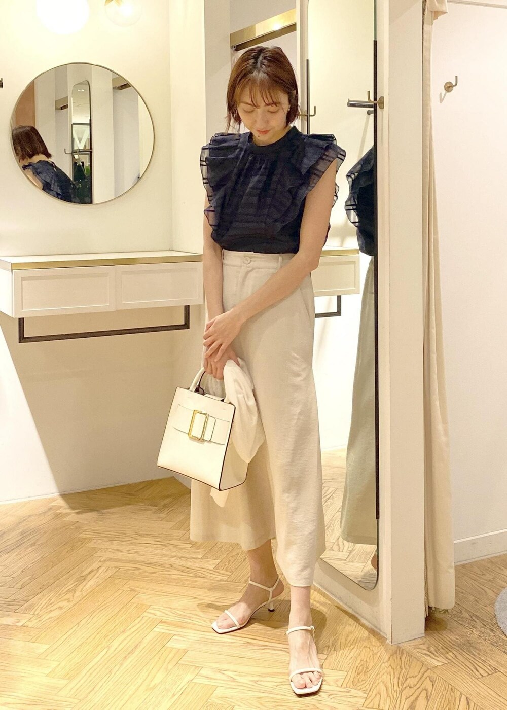 ホワイト系のサンダル、ホワイト系のスカート、ブルー系のシャツ/ブラウスを着用したレディースの春コーディネートの4枚目の写真