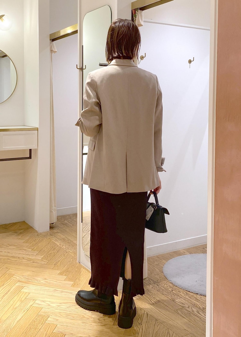 ブラック系のショルダーバッグ、ブラック系のブーツ、ベージュ系のテーラードジャケットを着用したレディースの秋コーディネートの2枚目の写真