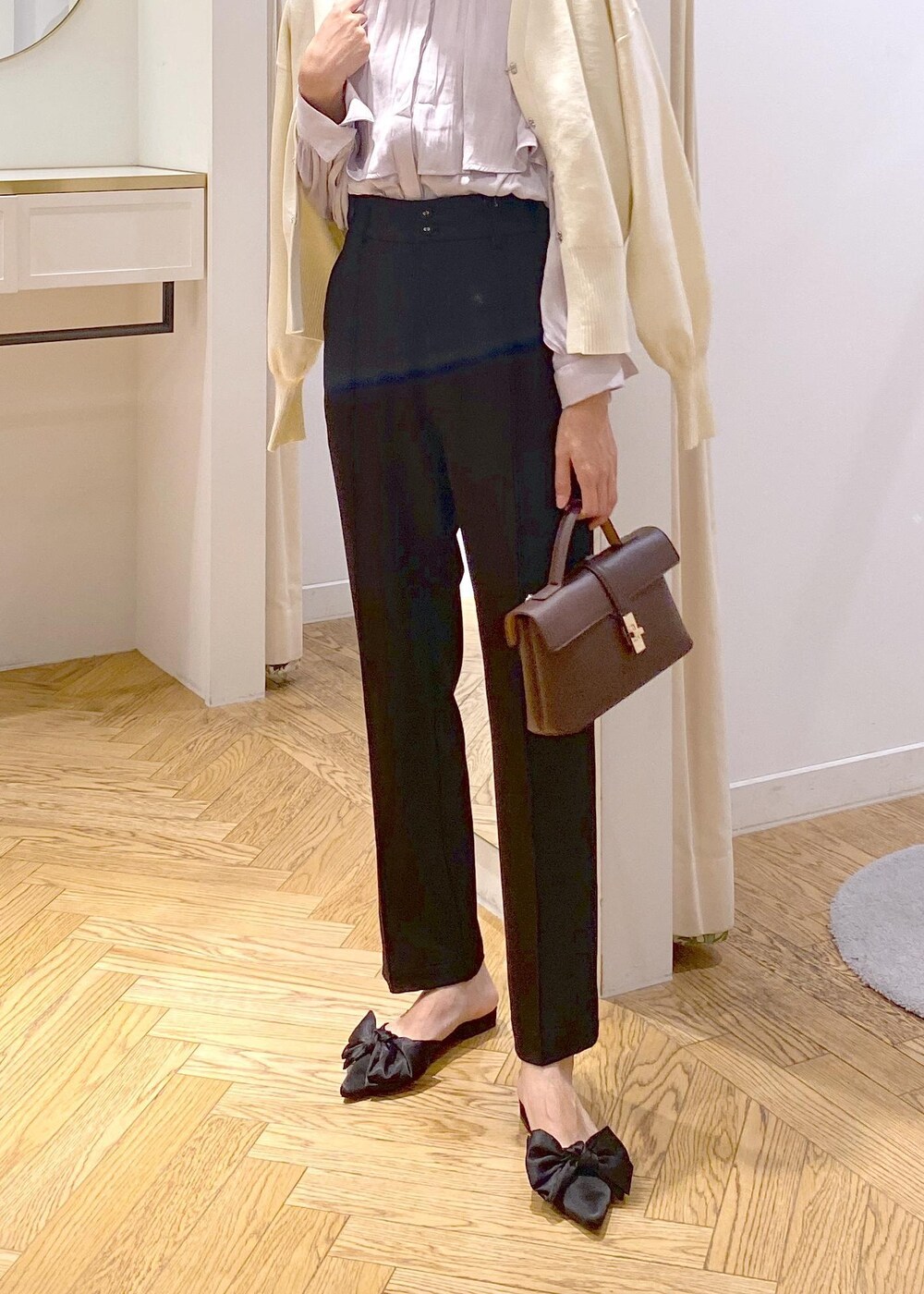 ブラウン系のショルダーバッグ、ブラック系のサンダル、ブラック系のスラックスを着用したレディースの秋コーディネートの4枚目の写真