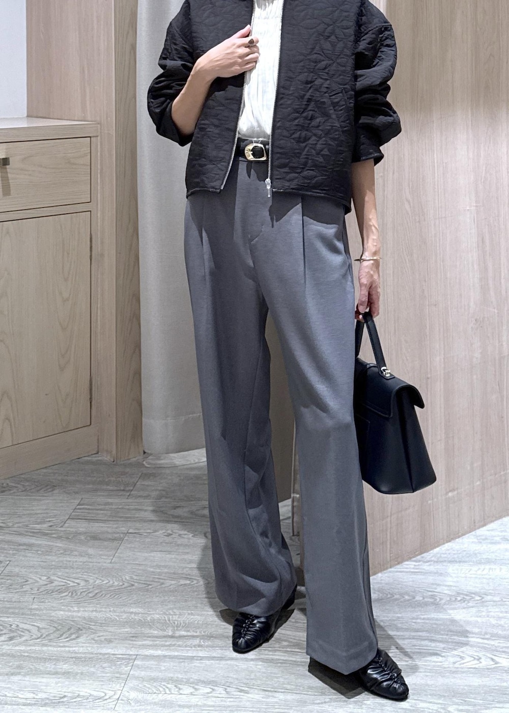 ブラック系のハンドバッグ、グレー系のスラックス、ホワイト系のシャツ/ブラウスを着用したレディースの秋コーディネートの10枚目の写真