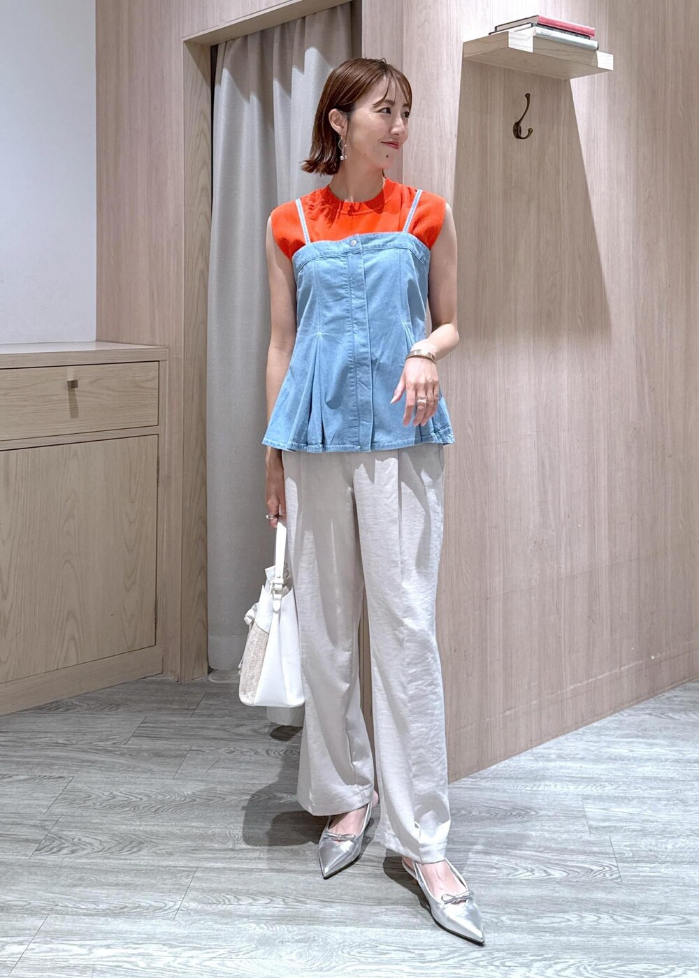 シルバー系のパンプス、ブルー系のキャミソール、オレンジ系のニット/セーターを着用したレディースの夏コーディネートの2枚目の写真