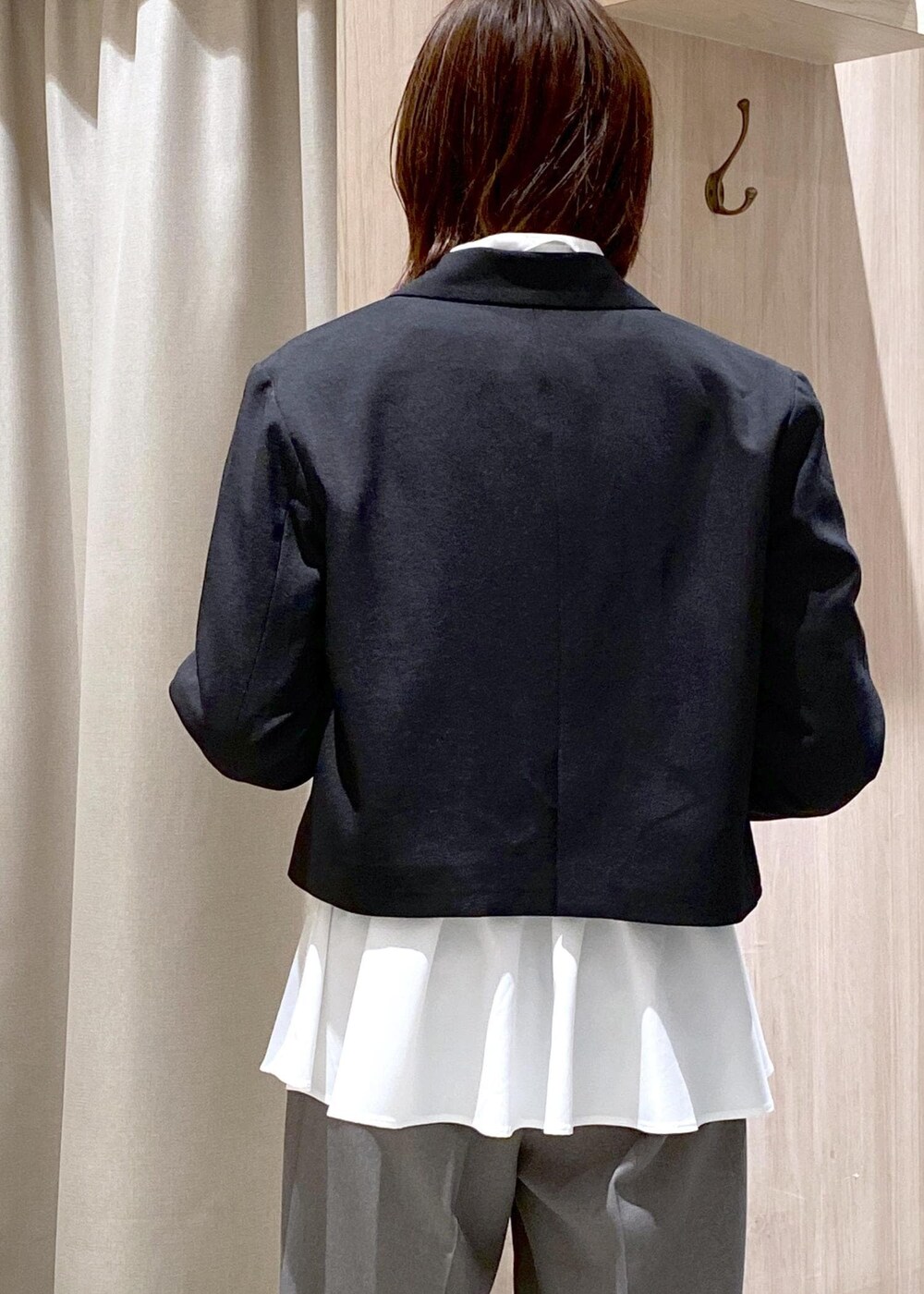 ブラック系のショルダーバッグ、グレー系のスラックス、ホワイト系のカーディガン/ボレロを着用したレディースの冬コーディネートの8枚目の写真