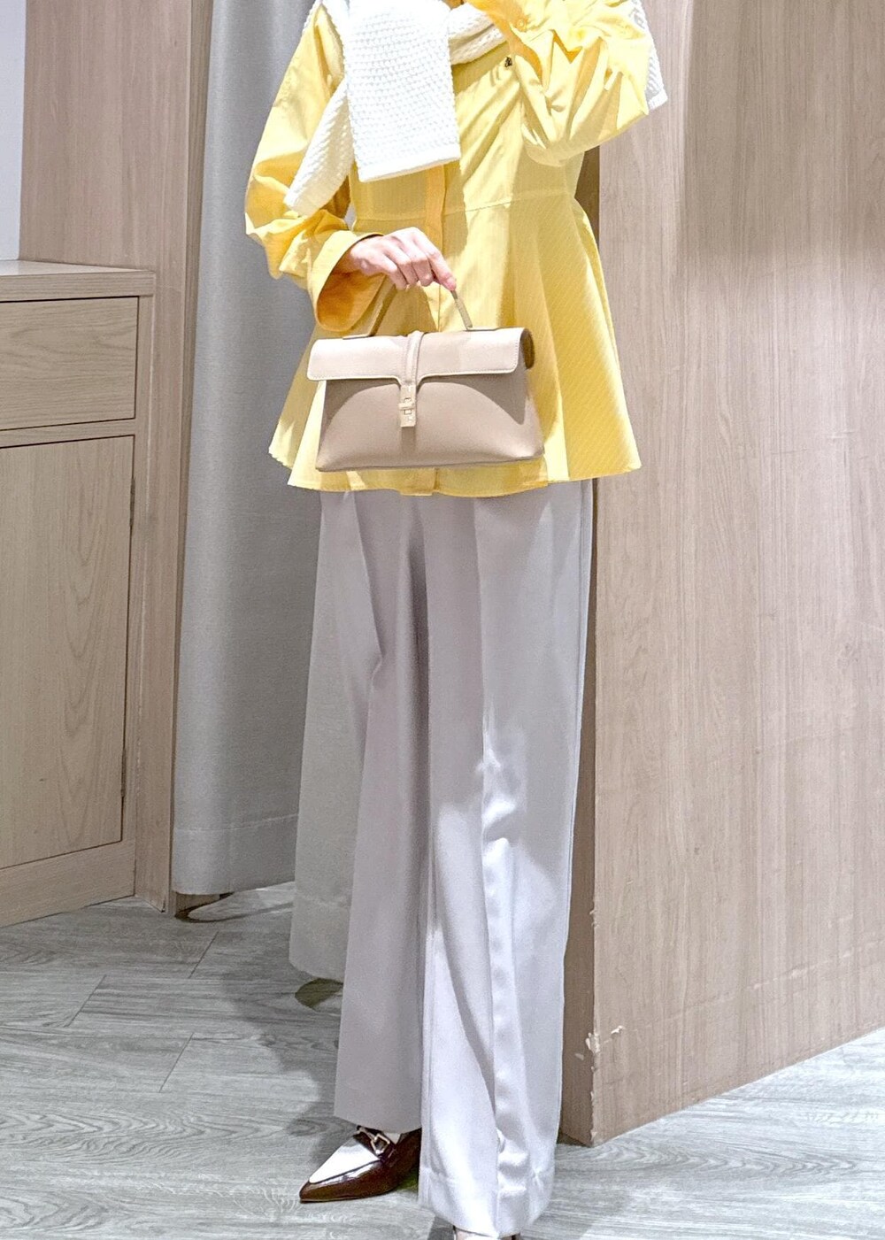 ベージュ系のショルダーバッグ、ブラウン系のパンプス、イエロー系のシャツ/ブラウスを着用したレディースの春コーディネートの5枚目の写真