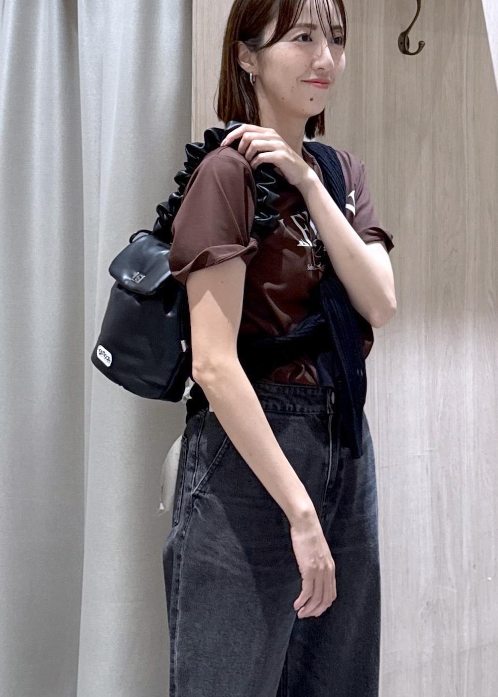ブラック系のデニムパンツ、ブラック系のショルダーバッグ、ブラック系のカーディガン/ボレロを着用したレディースの夏コーディネートの5枚目の写真