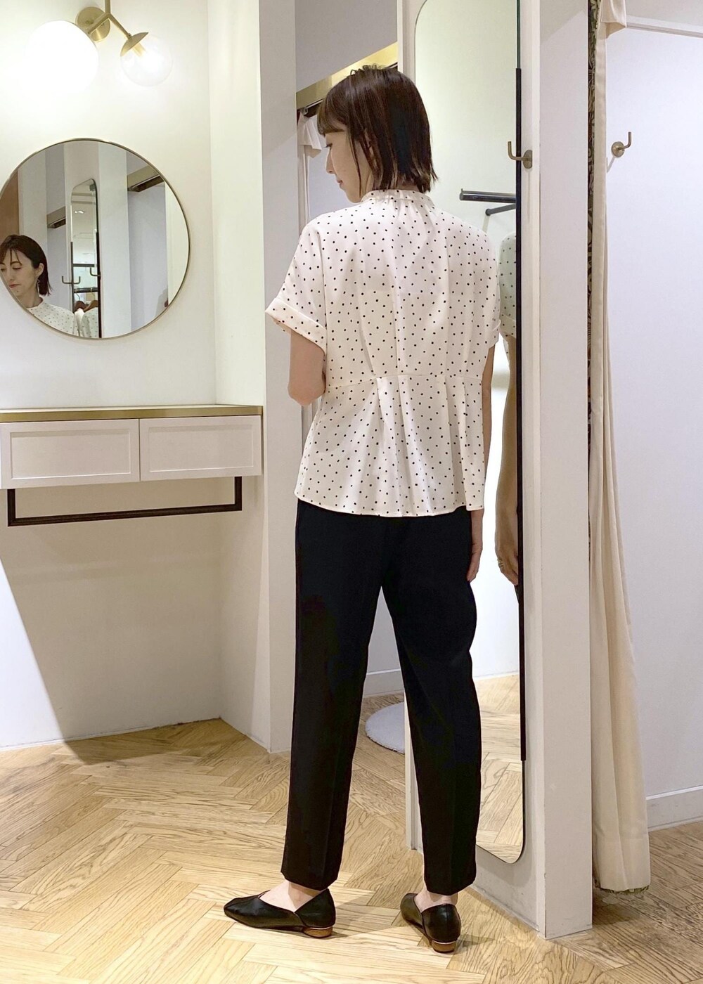 ホワイト系のキャミソール、ブラック系のパンプス、ホワイト系のトートバッグを着用したレディースの春コーディネートの2枚目の写真