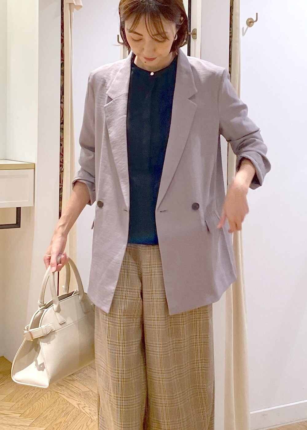 グレー系のテーラードジャケット、ブラック系のバレエシューズ、ベージュ系のトートバッグを着用したレディースの秋コーディネートの4枚目の写真