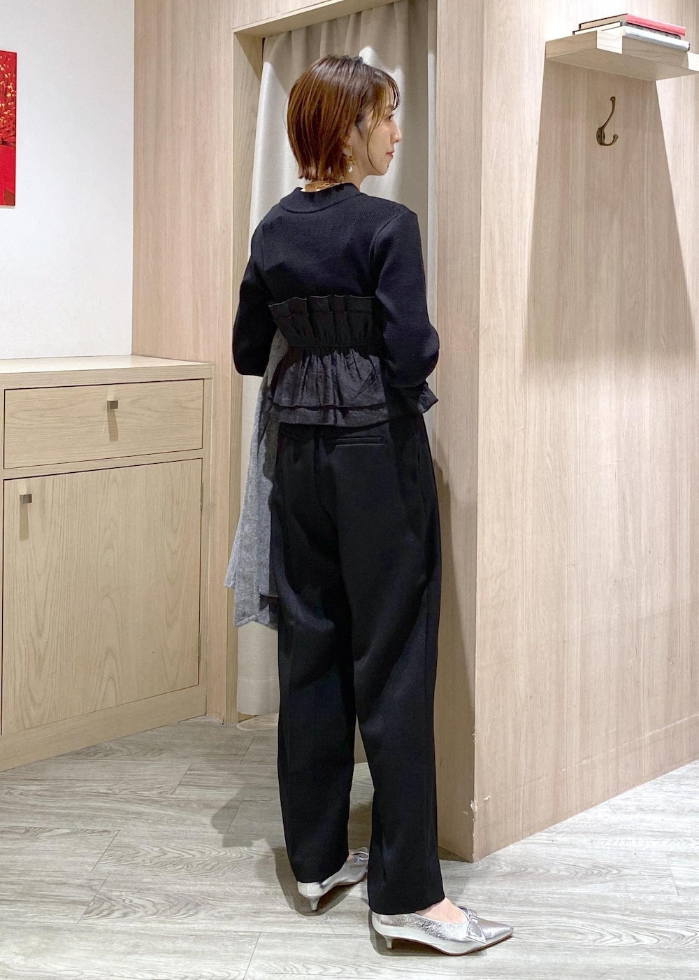 シルバー系のパンプス、ブラック系のスラックス、ブラック系のニット/セーターを着用したレディースの冬コーディネートの9枚目の写真