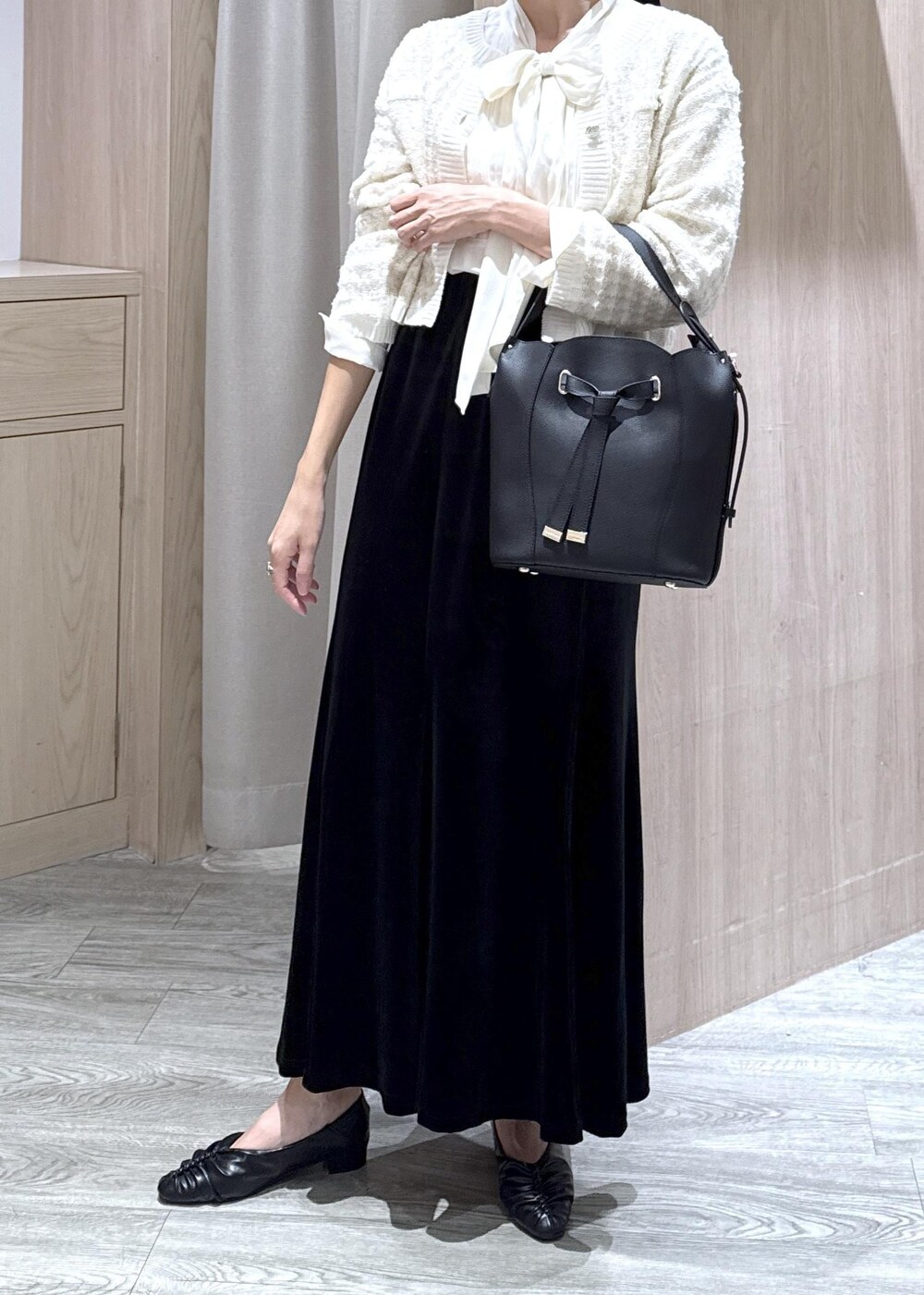 ブラック系のパンプス、ホワイト系のカーディガン/ボレロ、ブラック系のショルダーバッグを着用したレディースの秋コーディネートの8枚目の写真