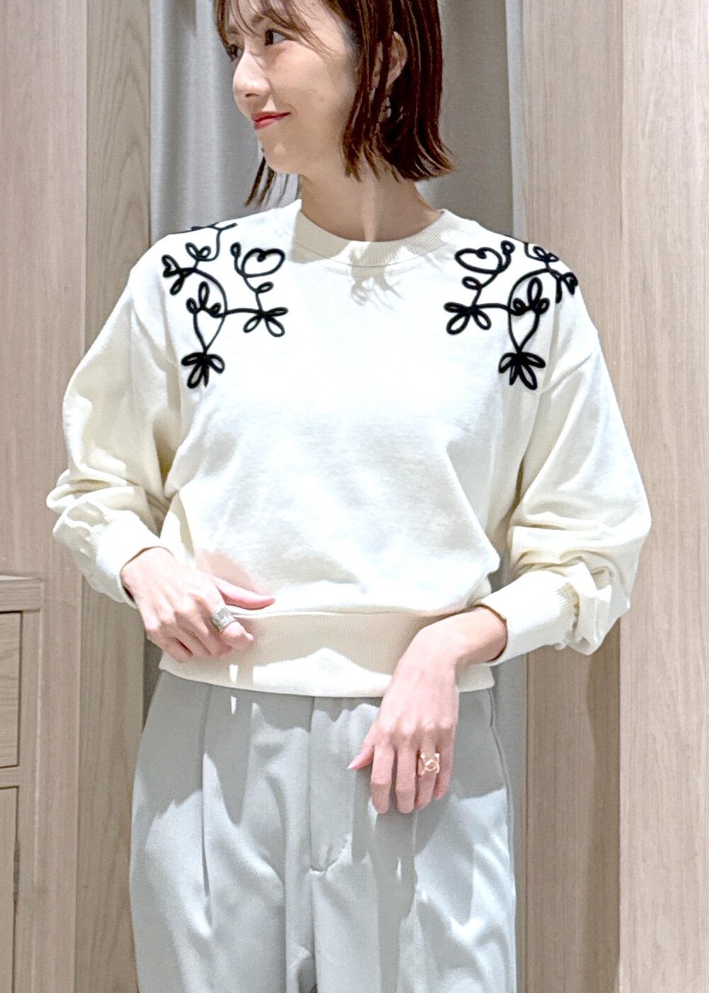 ブルー系のマウンテンパーカー、ホワイト系のニット/セーター、グリーン系のスラックスを着用したレディースの冬コーディネートの7枚目の写真