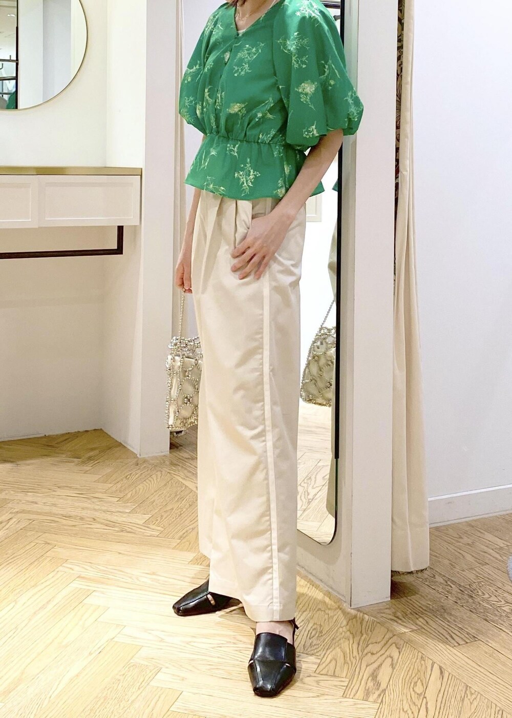 ホワイト系のスラックス、ブラック系のサンダル、ホワイト系のキャミソールを着用したレディースの春コーディネートの4枚目の写真