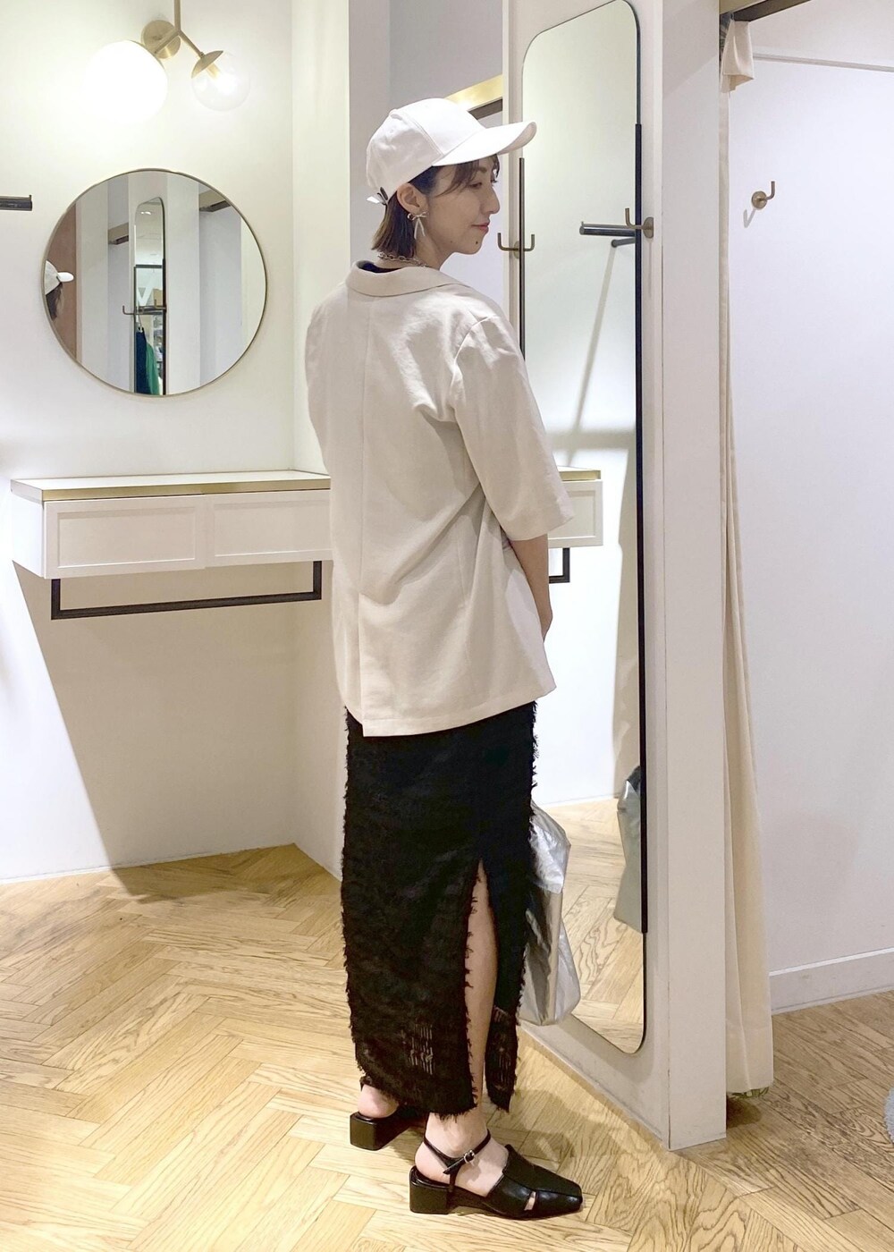 ブラック系のサンダル、ブラック系のスカート、ブラック系のキャミソールを着用したレディースの春コーディネートの3枚目の写真