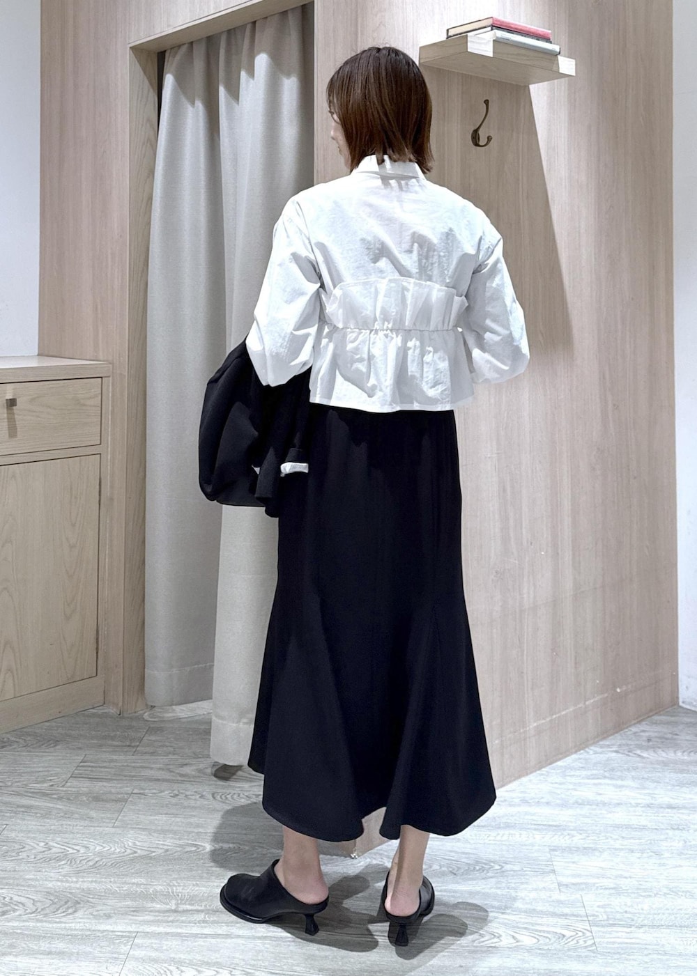 ブラック系のショルダーバッグ、ブラック系のスカート、ブラック系のテーラードジャケットを着用したレディースの冬コーディネートの9枚目の写真