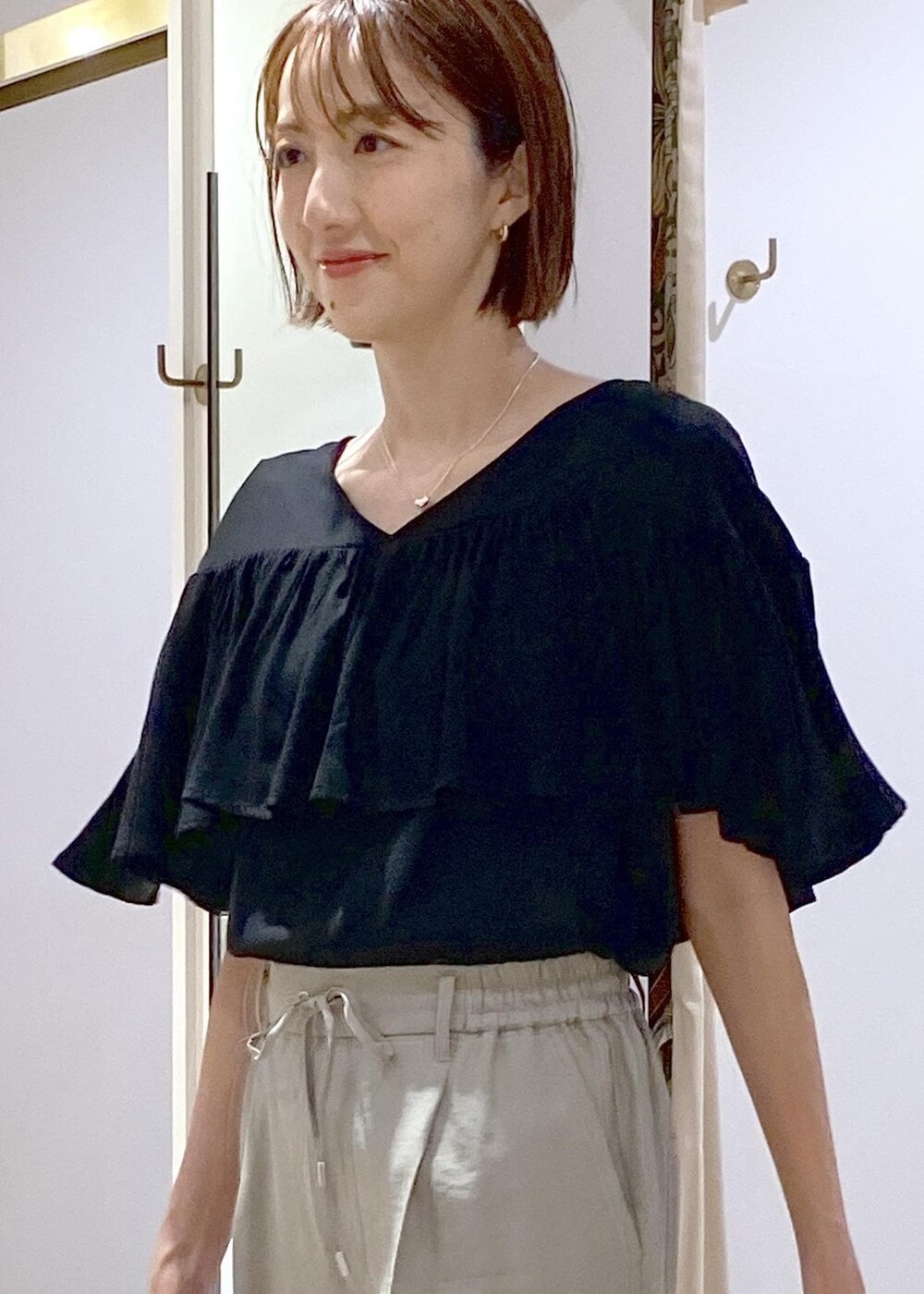 グリーン系のスラックス、ホワイト系のサンダル、ホワイト系のハンドバッグを着用したレディースの夏コーディネートの6枚目の写真