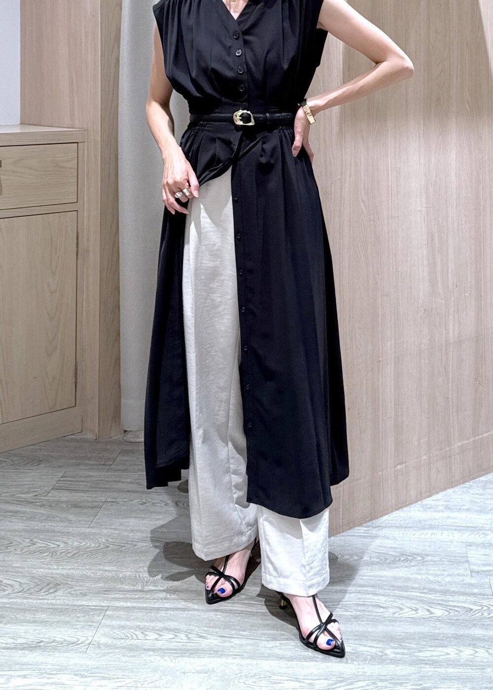 ブラック系のサンダル、ホワイト系のスラックス、ブラック系のワンピースを着用したレディースの夏コーディネートの6枚目の写真