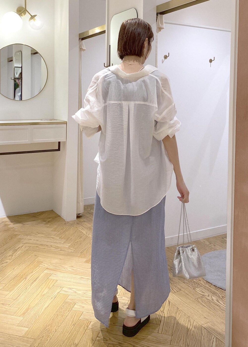 ホワイト系のサンダル、ブルー系のワンピース、シルバー系のショルダーバッグを着用したレディースの夏コーディネートの3枚目の写真