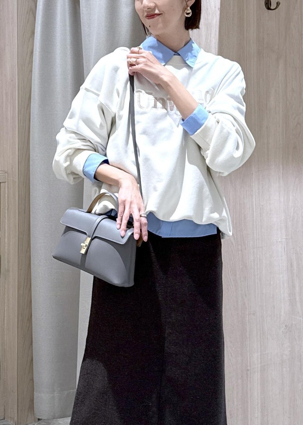 グレー系のショルダーバッグ、ブラック系のブーツ、ブラウン系のスカートを着用したレディースの秋コーディネートの3枚目の写真