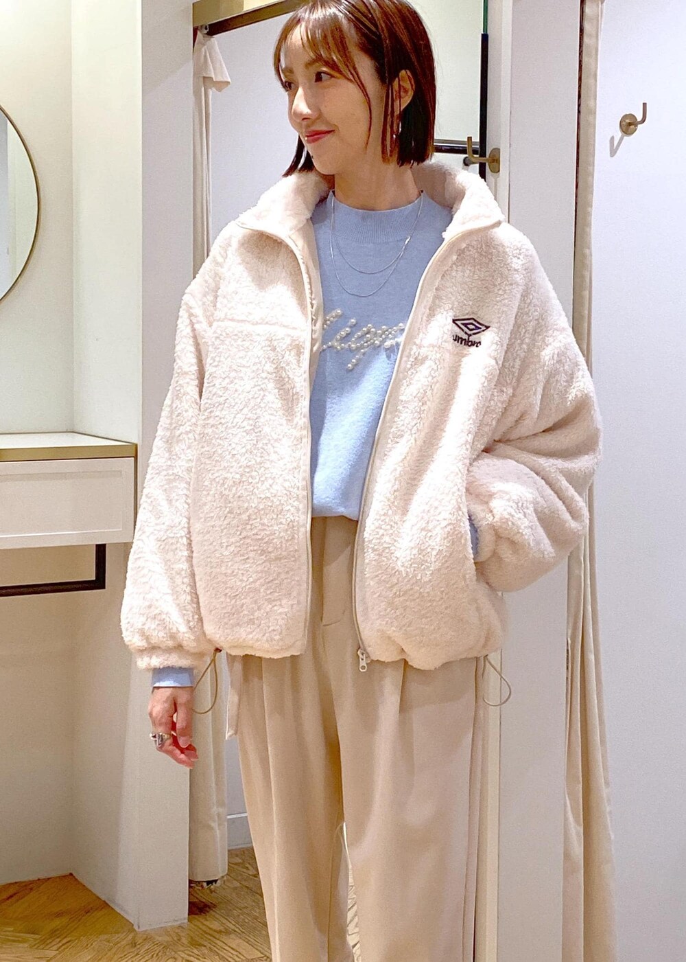 ホワイト系のブーツ、ホワイト系のブルゾン、ブルー系のニット/セーターを着用したレディースの冬コーディネートの7枚目の写真