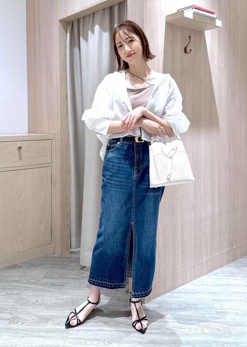 ブルー系のデニムスカート、ベージュ系のキャミソール、ブラック系のサンダルを着用したレディースの夏コーディネートの2枚目の写真