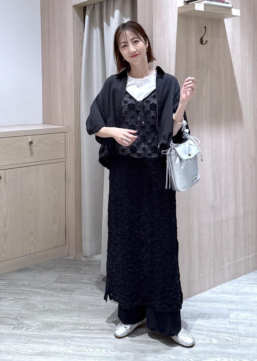 シルバー系のショルダーバッグ、ホワイト系のTシャツ/カットソー、ブラック系のワンピースを着用したレディースの春コーディネートの4枚目の写真