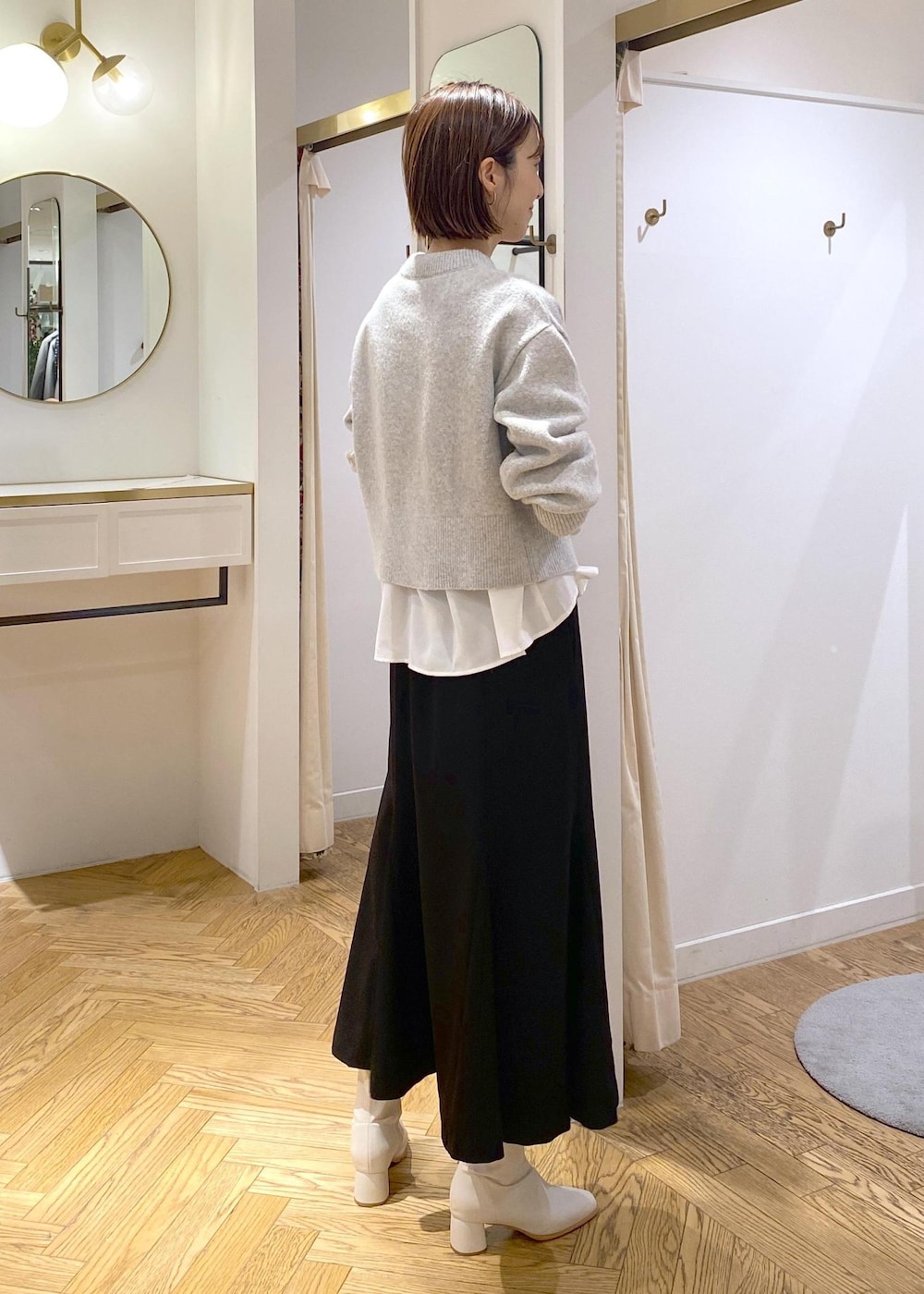 ホワイト系のシャツ/ブラウス、グレー系のカーディガン/ボレロ、ホワイト系のブーツを着用したレディースの冬コーディネートの4枚目の写真