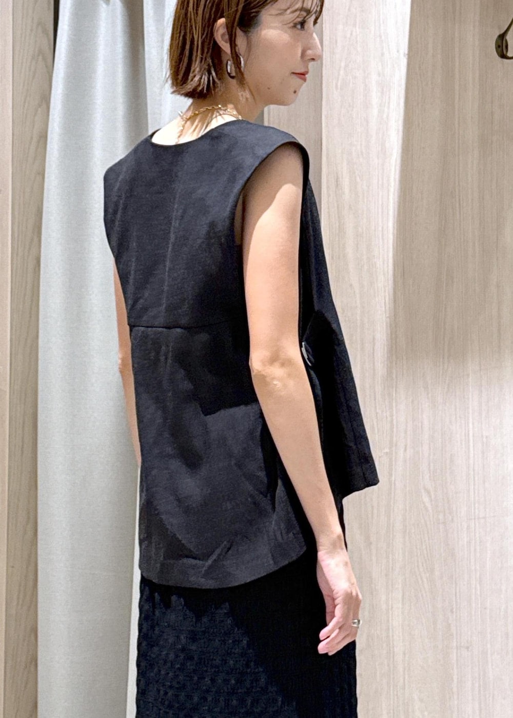 ベージュ系のキャミソール、ブラック系のスカート、グレー系のベストを着用したレディースの夏コーディネートの8枚目の写真