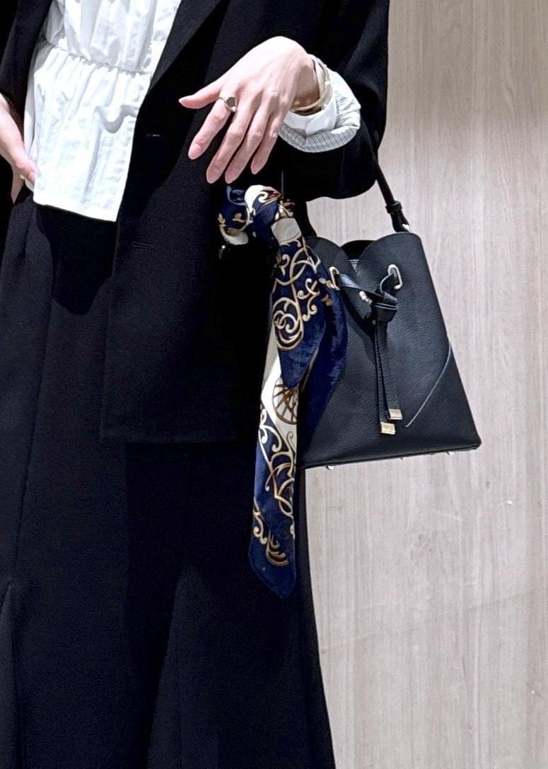 ブラック系のショルダーバッグ、ブラック系のスカート、ブラック系のテーラードジャケットを着用したレディースの冬コーディネートの6枚目の写真