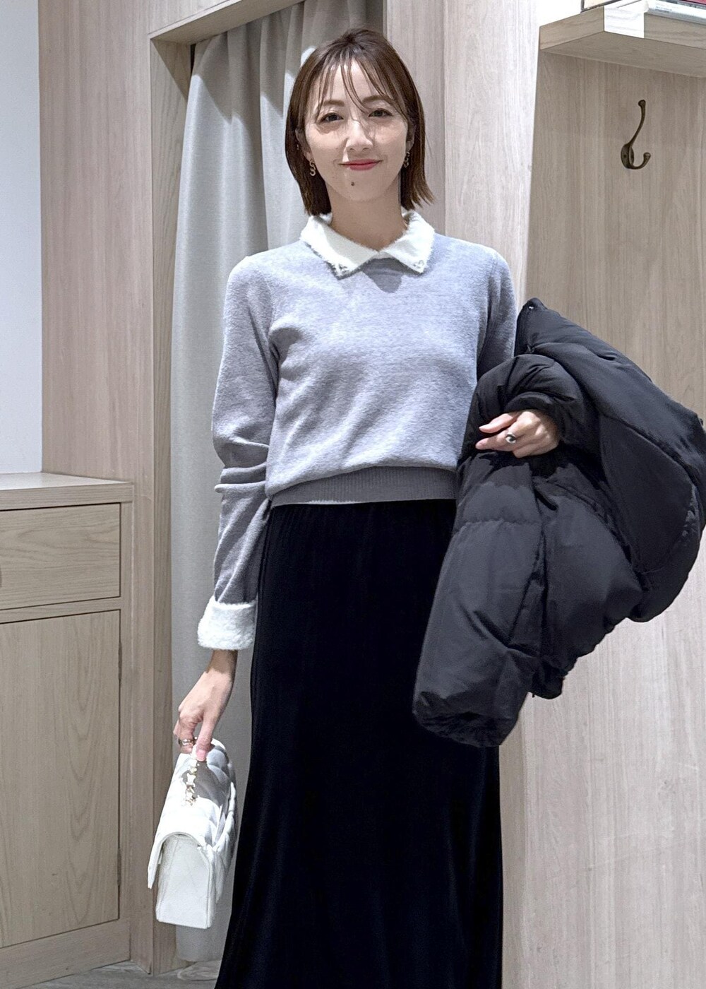 ブラック系のブーツ、ブラック系のスカート、ブラック系のダウンジャケット/コートを着用したレディースの冬コーディネートの8枚目の写真