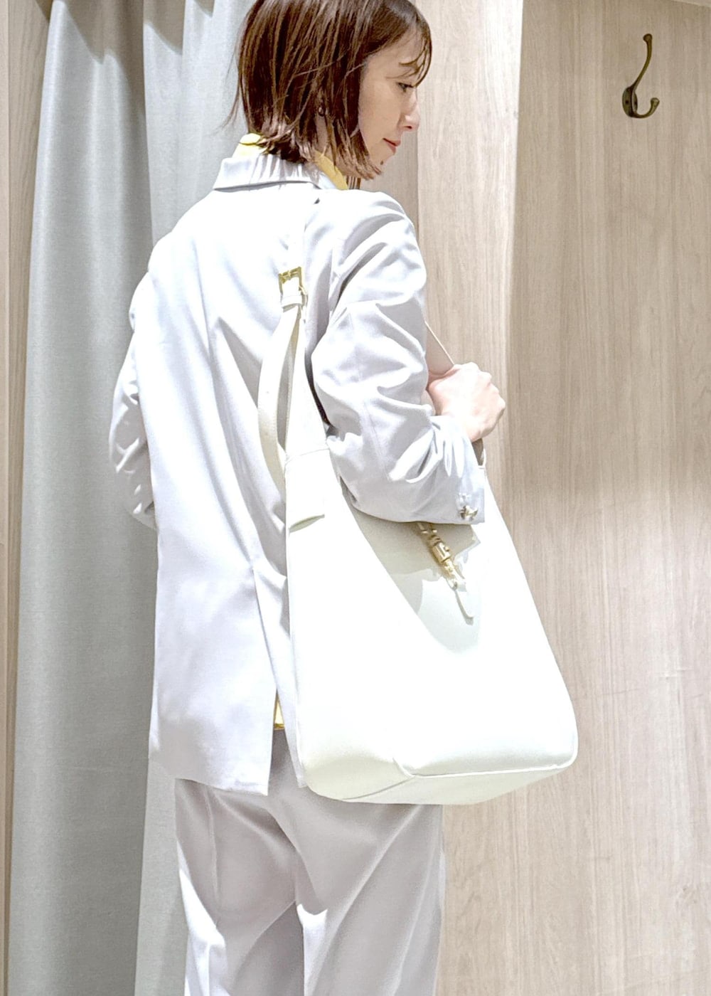 ブラウン系のパンプス、イエロー系のシャツ/ブラウス、ベージュ系のスラックスを着用したレディースの春コーディネートの7枚目の写真