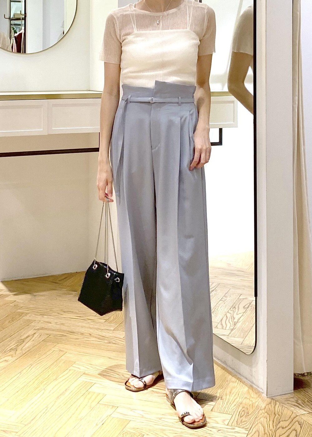 ベージュ系のサンダル、ブルー系のスラックス、ブラック系のショルダーバッグを着用したレディースの夏コーディネートの5枚目の写真