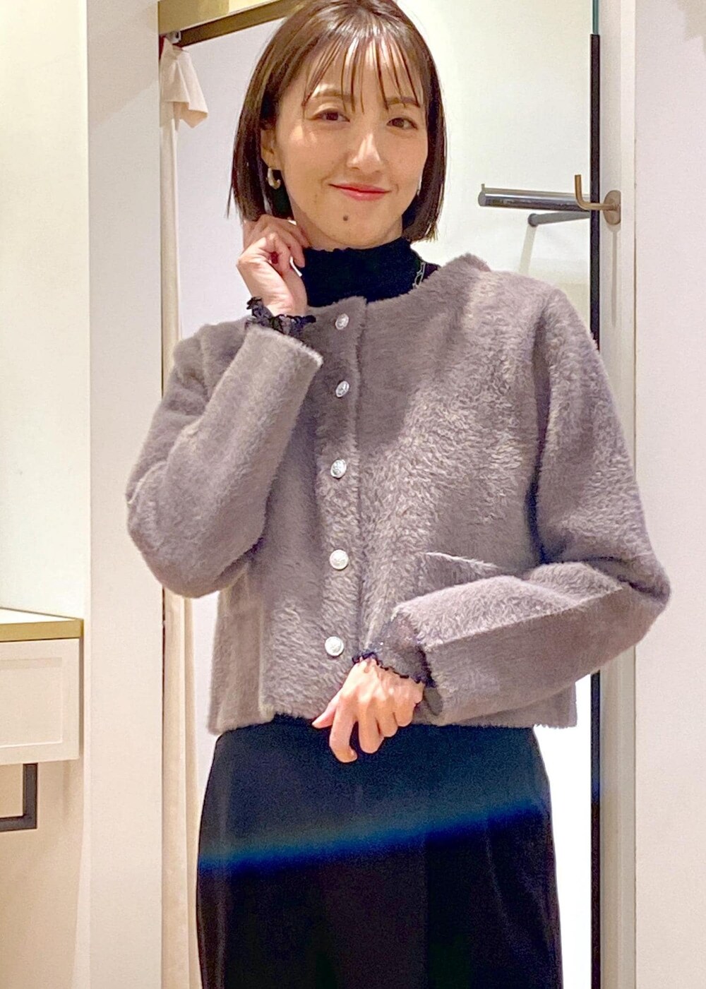 シルバー系のパンプス、ブラウン系のカーディガン/ボレロ、ブラック系のTシャツ/カットソーを着用したレディースの冬コーディネートの6枚目の写真