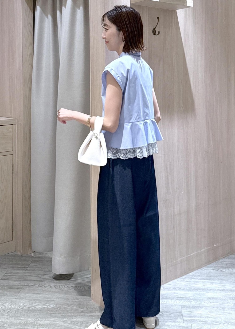 ホワイト系のパンプス、ホワイト系のショルダーバッグ、ブラック系のキャミソールを着用したレディースの春コーディネートの2枚目の写真