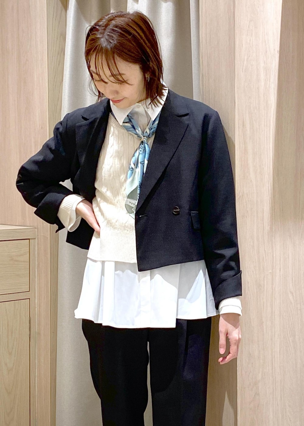 ブラック系のパンプス、ホワイト系のカーディガン/ボレロ、ブラック系のハンドバッグを着用したレディースの冬コーディネートの6枚目の写真