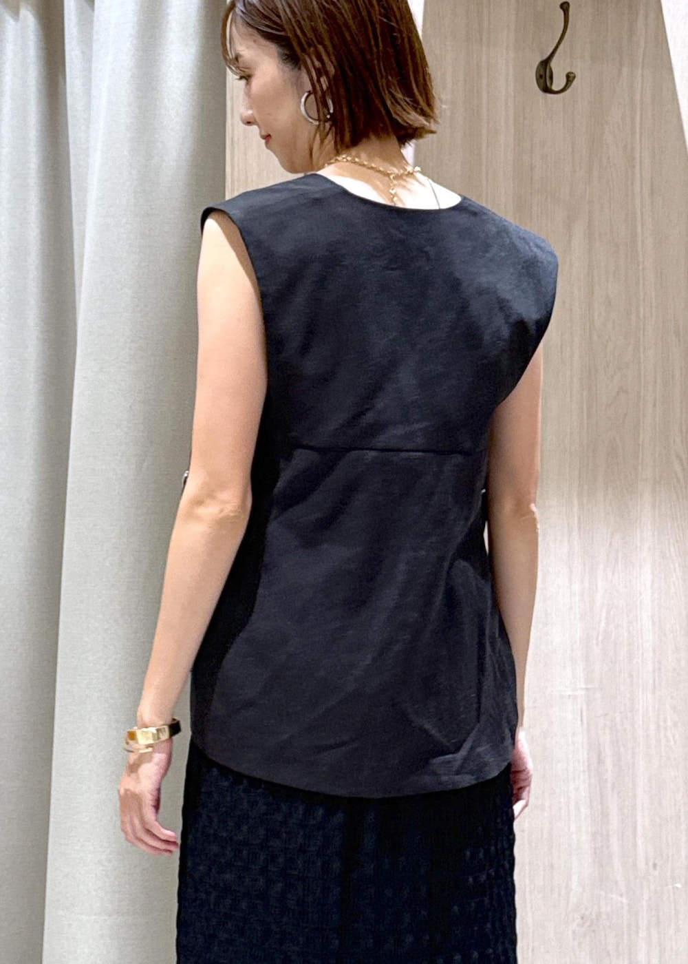 ベージュ系のキャミソール、ブラック系のスカート、グレー系のベストを着用したレディースの夏コーディネートの7枚目の写真