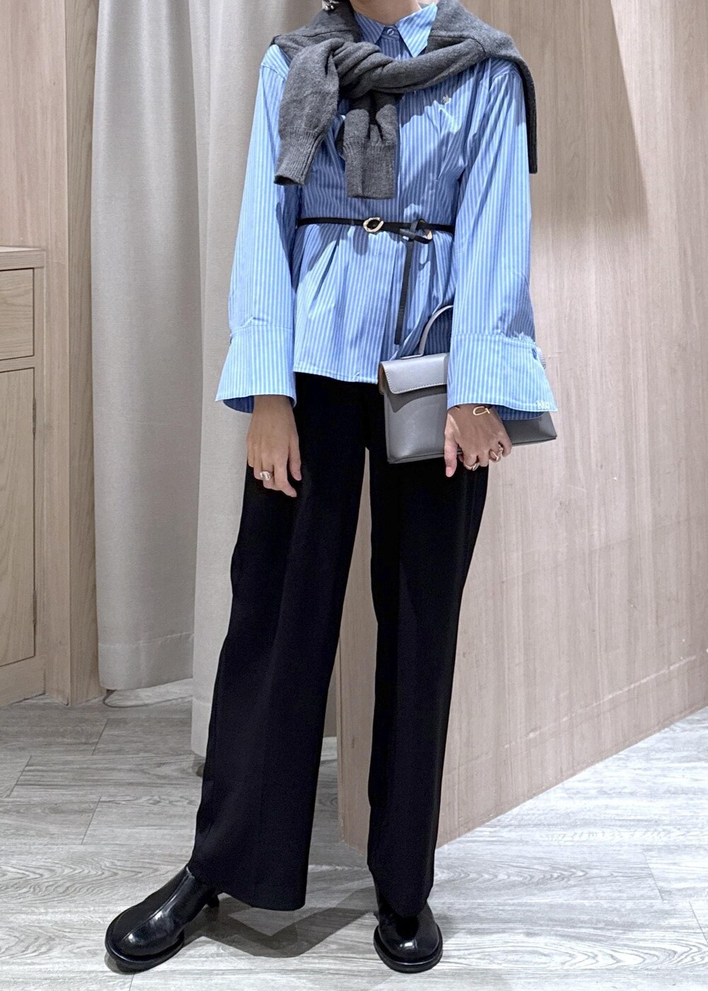 グレー系のショルダーバッグ、ブラック系のスラックス、グレー系のカーディガン/ボレロを着用したレディースの秋コーディネートの3枚目の写真