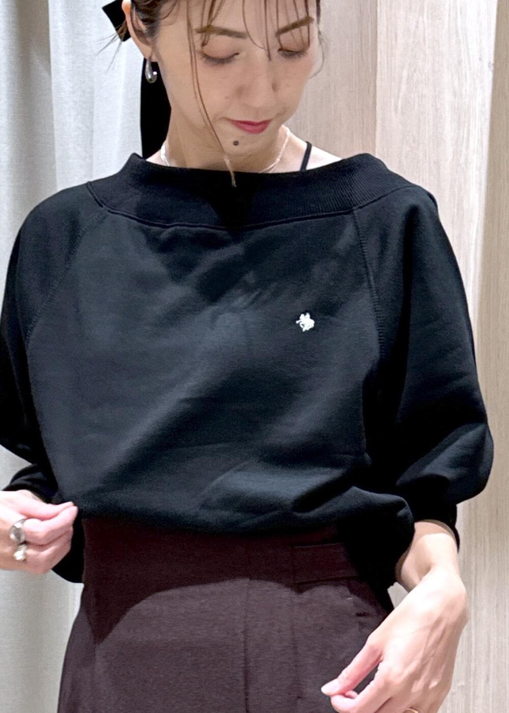 ブラック系のキャミソール、ブラウン系のスカート、ブラック系のブーツを着用したレディースの秋コーディネートの7枚目の写真