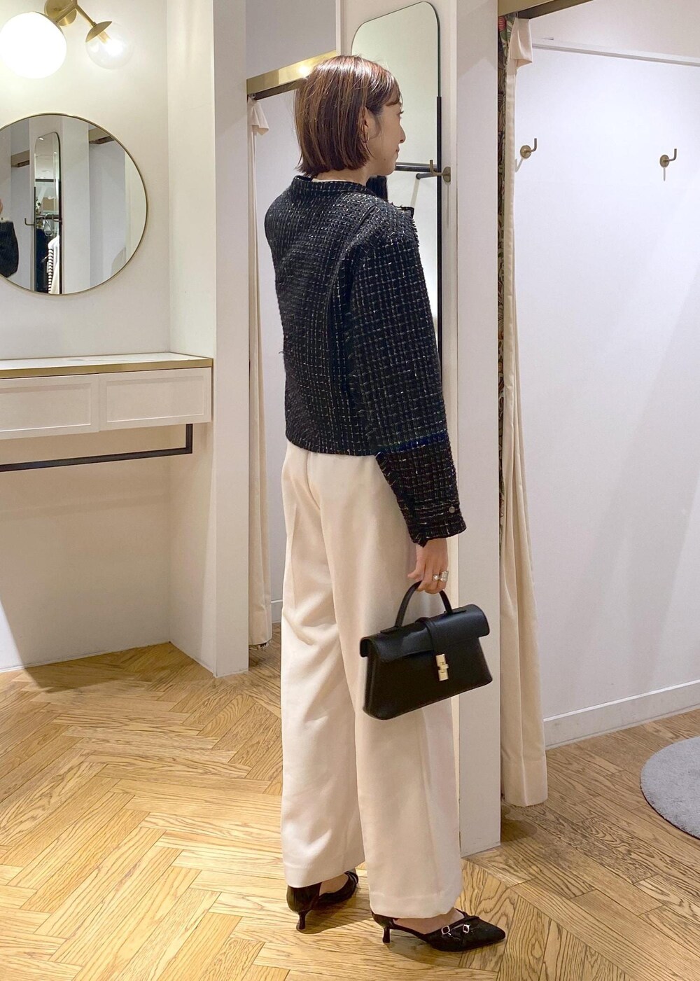 ブラック系のパンプス、ベージュ系のシャツ/ブラウス、ホワイト系のスラックスを着用したレディースの冬コーディネートの4枚目の写真