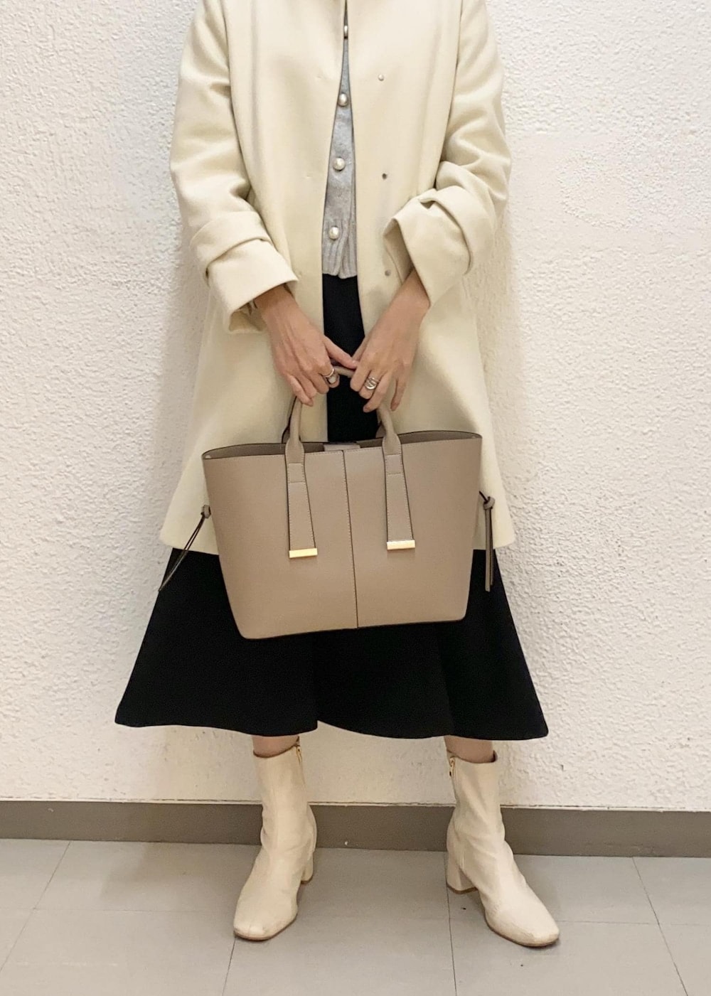 グレー系のカーディガン/ボレロ、ベージュ系のトートバッグ、ホワイト系のその他アウターを着用したレディースの冬コーディネートの4枚目の写真