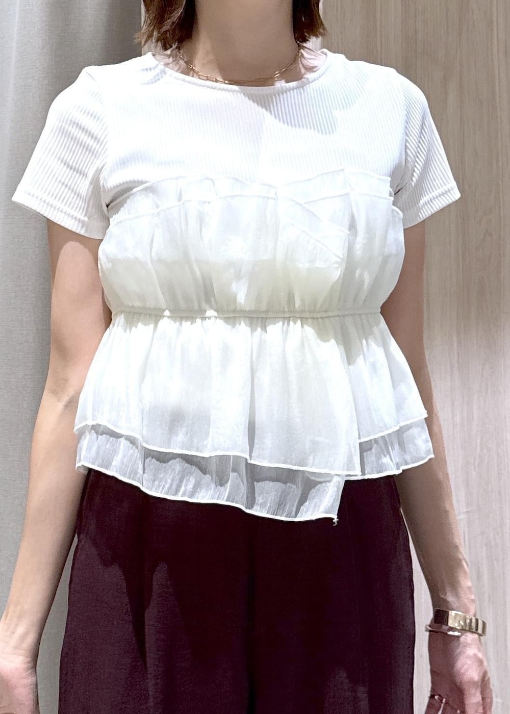 グレー系のトートバッグ、ブラック系のパンプス、ホワイト系のTシャツ/カットソーを着用したレディースの夏コーディネートの6枚目の写真