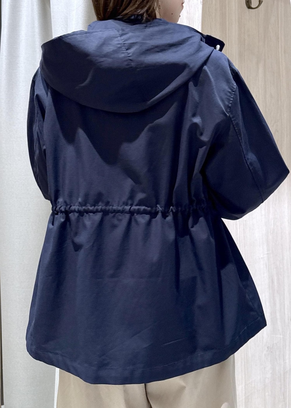 ホワイト系のカーディガン/ボレロ、ホワイト系のトートバッグ、ブルー系のナイロンジャケットを着用したレディースの春コーディネートの7枚目の写真