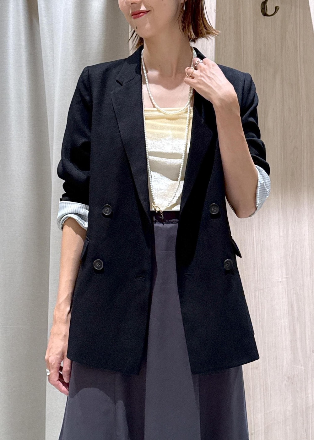 ブラック系のパンプス、ブラック系のテーラードジャケット、ベージュ系のショルダーバッグを着用したレディースの秋コーディネートの8枚目の写真