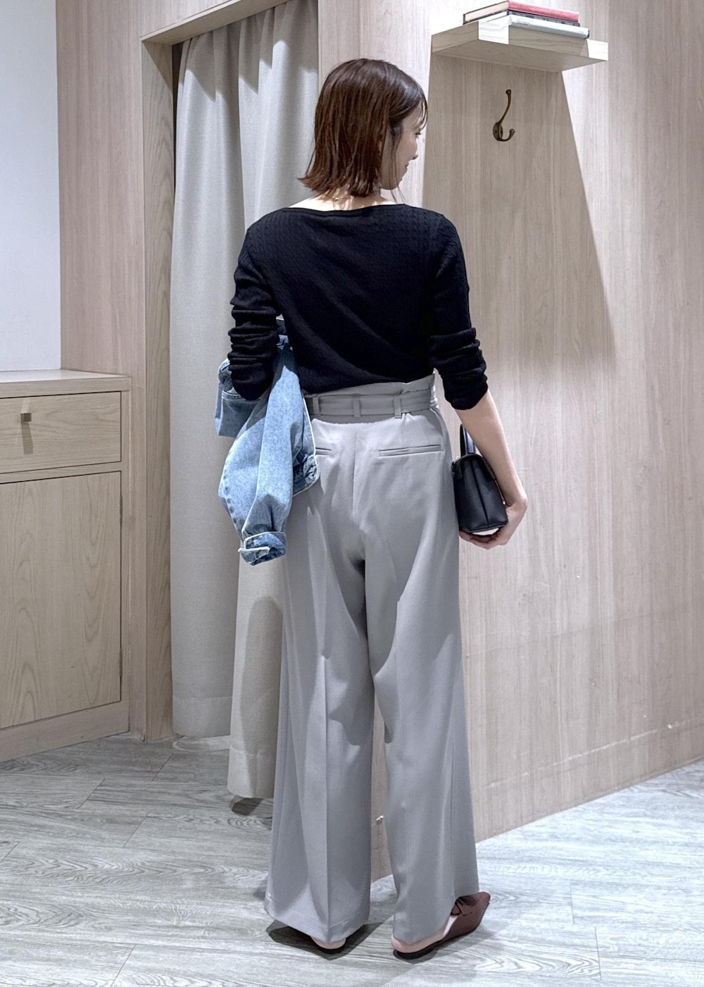 ブラック系のショルダーバッグ、ブルー系のデニムジャケット、グレー系のスラックスを着用したレディースの春コーディネートの10枚目の写真