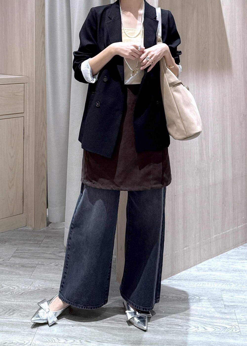 シルバー系のパンプス、ベージュ系のショルダーバッグ、ブラック系のテーラードジャケットを着用したレディースの秋コーディネートの4枚目の写真