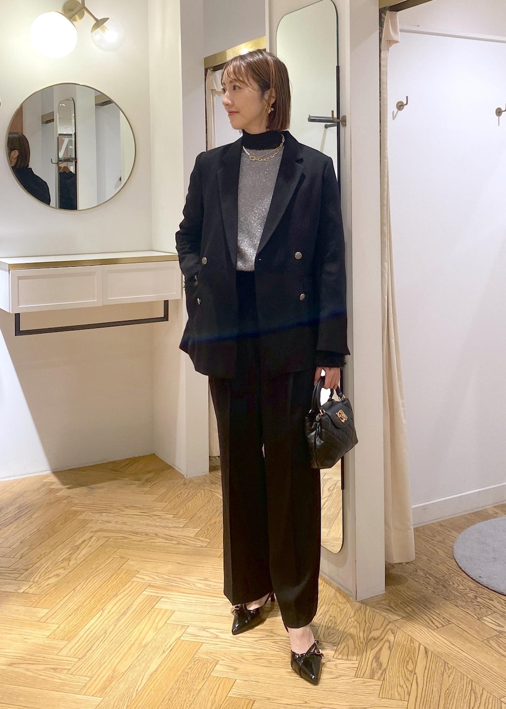 ブラック系のニット/セーター、ブラック系のスラックス、ブラック系のテーラードジャケットを着用したレディースの冬コーディネートの2枚目の写真