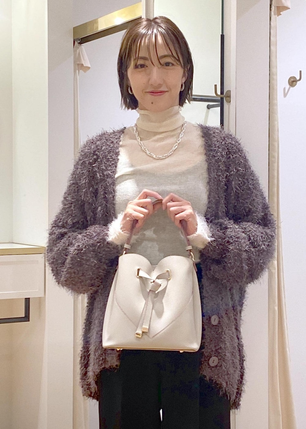 ブラック系のバレエシューズ、グレー系のカーディガン/ボレロ、ホワイト系のニット/セーターを着用したレディースの秋コーディネートの6枚目の写真